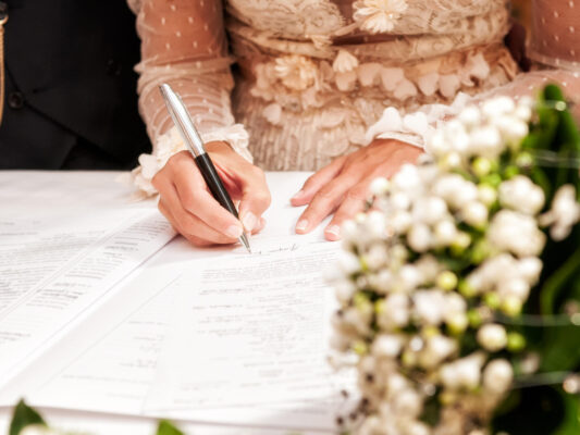 Detail of the hand of a bride who signs the marriage act