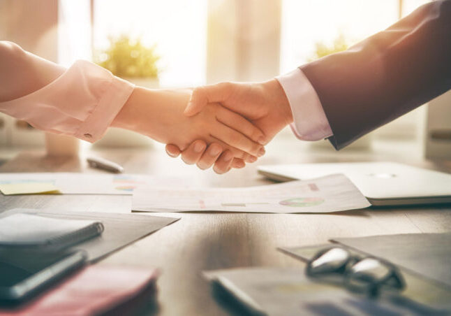 Man and woman are shaking hands in office. Collaborative teamwork.